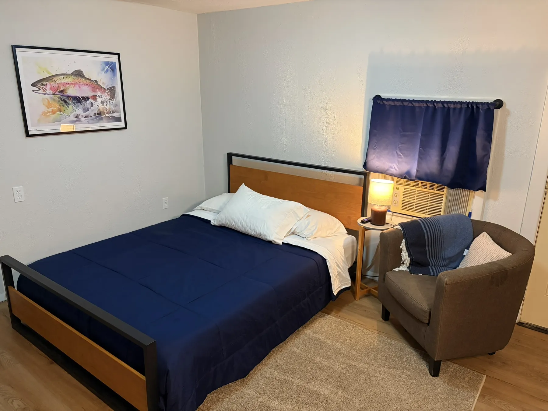 Motel bedroom with a blue bed cover and chair
