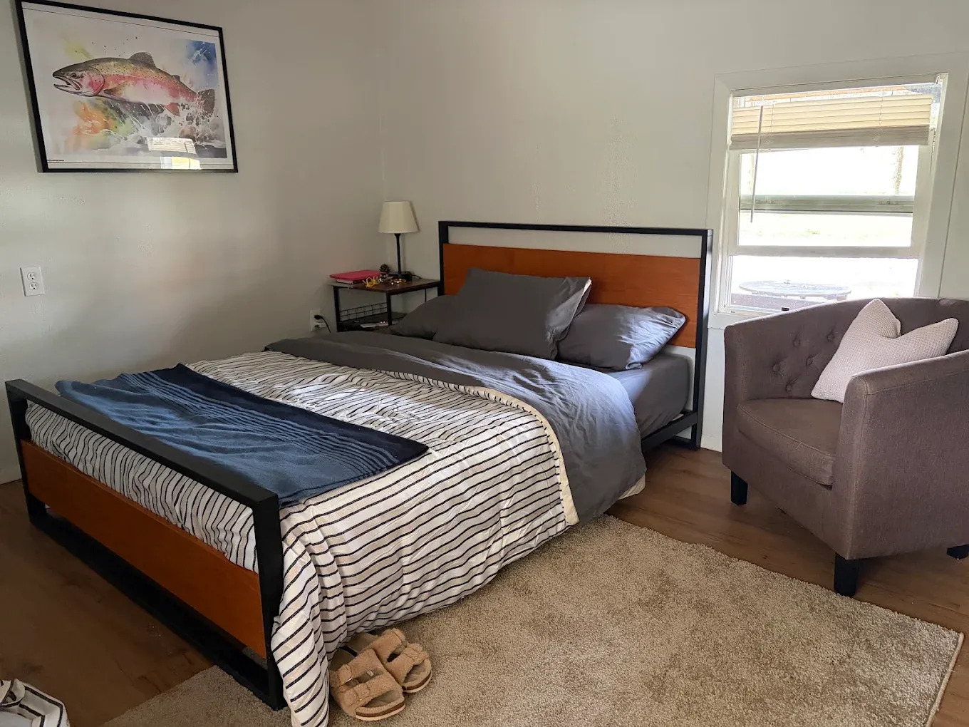 Motel bedroom with patterned bedding and a chair